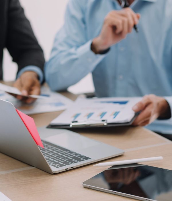 Financial analysts analyze business financial reports on a digital tablet planning investment project during a discussion at a meeting of corporate showing the results of their successful teamwork.